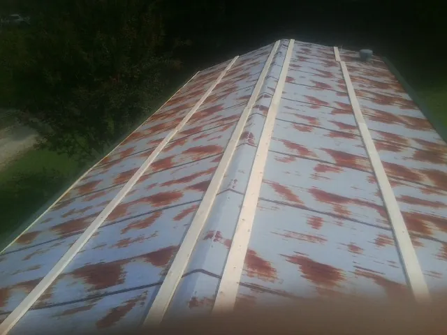 Rusted metal roof panels with new wood purlins before replacement — Storm Damage Roof Repair in Atco by Roofing Brothers