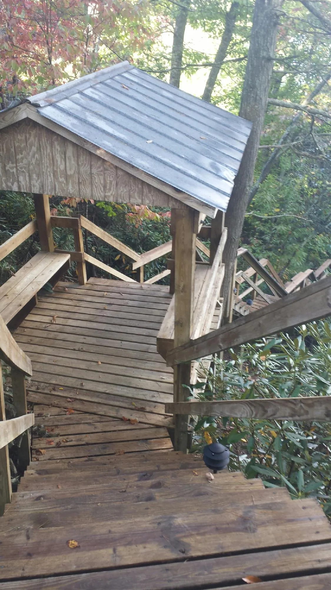 Metal roofed shelter over wooden steps on a wooded walkway — Skylight Repair & Installation work by our crew in Atco